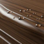 Close-up of water droplets beading effectively on a well-sealed dark wooden antique style bathroom vanity surface.